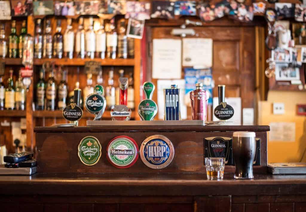 Image of bar with popular beer brand logos on display.