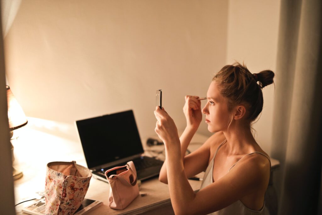 Image depicting a woman applying makeup